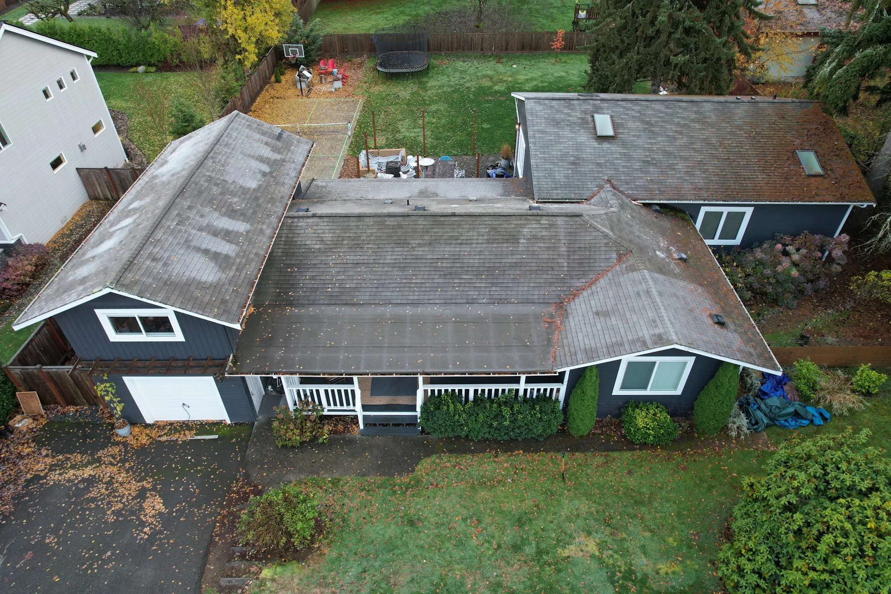 Aerial view of a home with a worn, moss-stained asphalt shingle roof before Titan Roofing's replacement