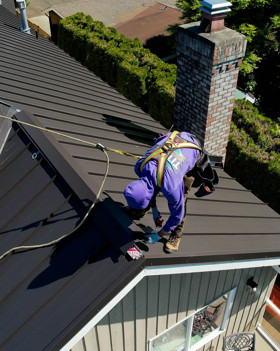 Titan Roofing crew member installing a new standing-seam metal roof