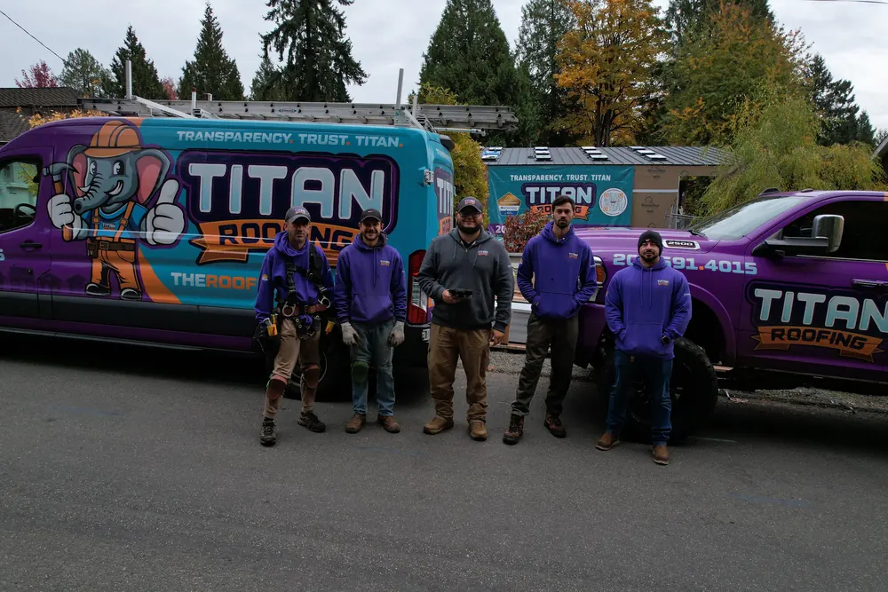The Titan Roofing crew in purple shirts next to the company van and truck